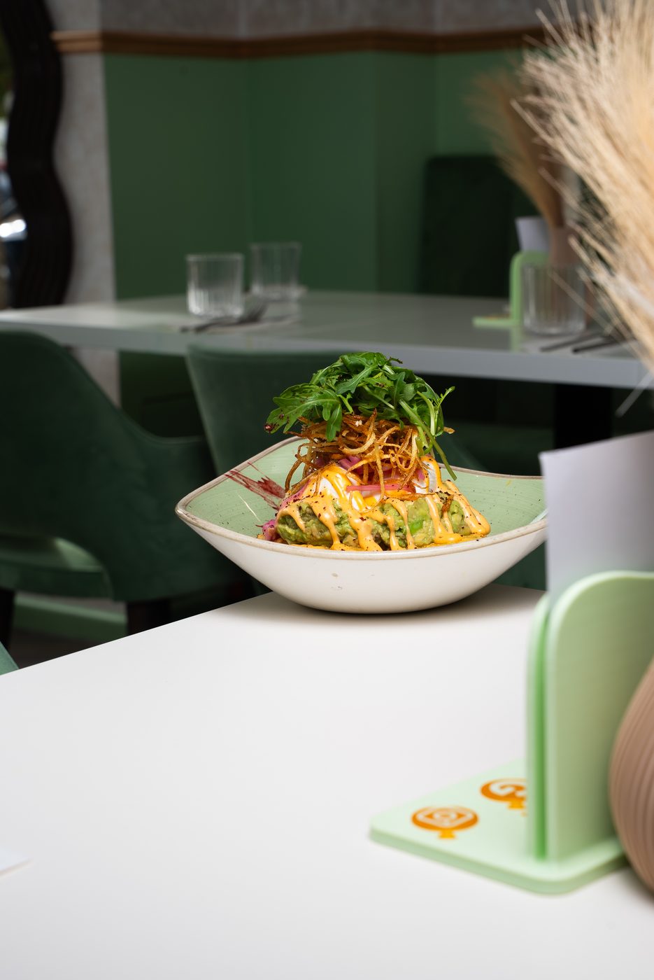 Avocado dish styled on a table inside a green dining room