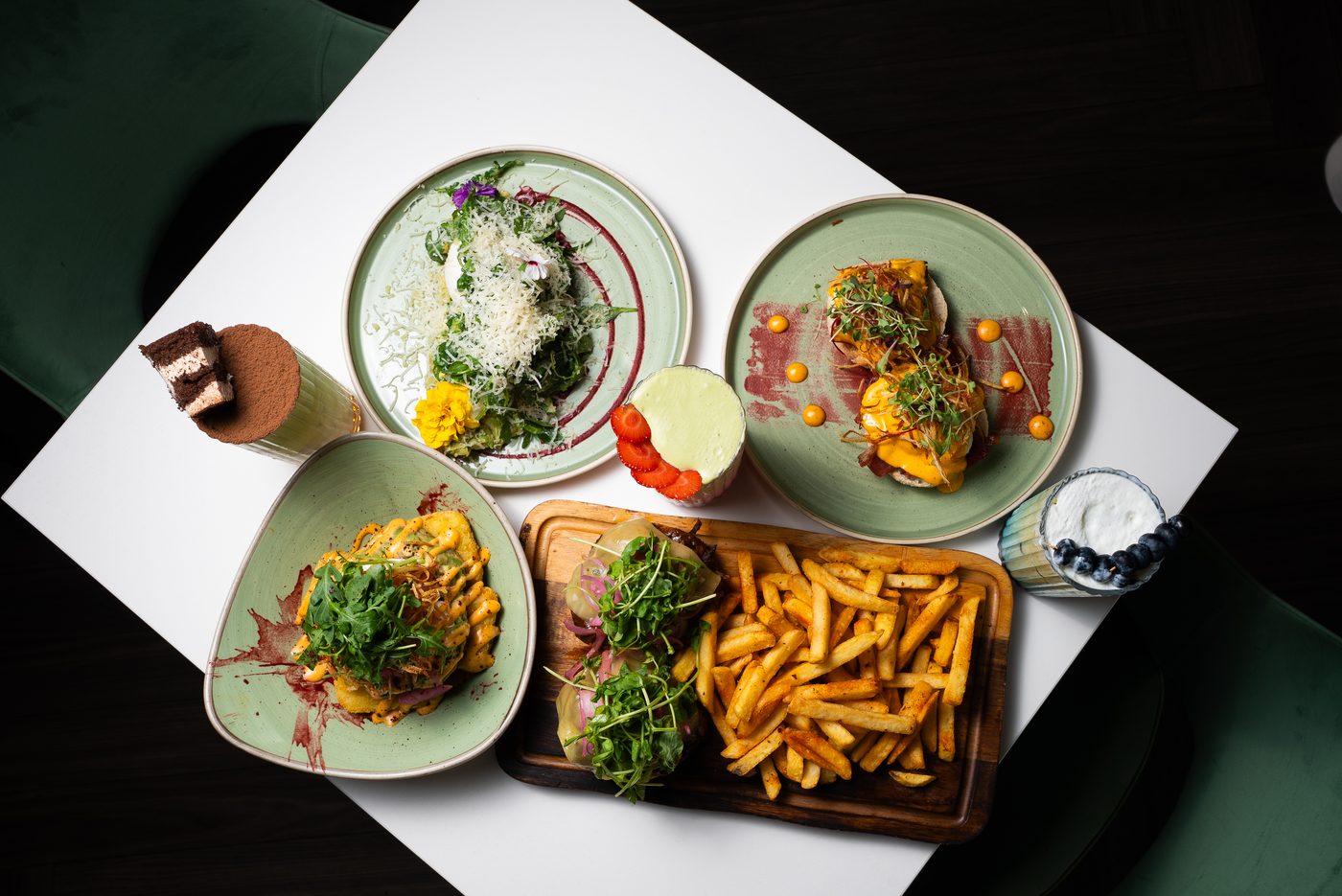 Overhead spread of brunch dishes, tiramisu, and cocktails