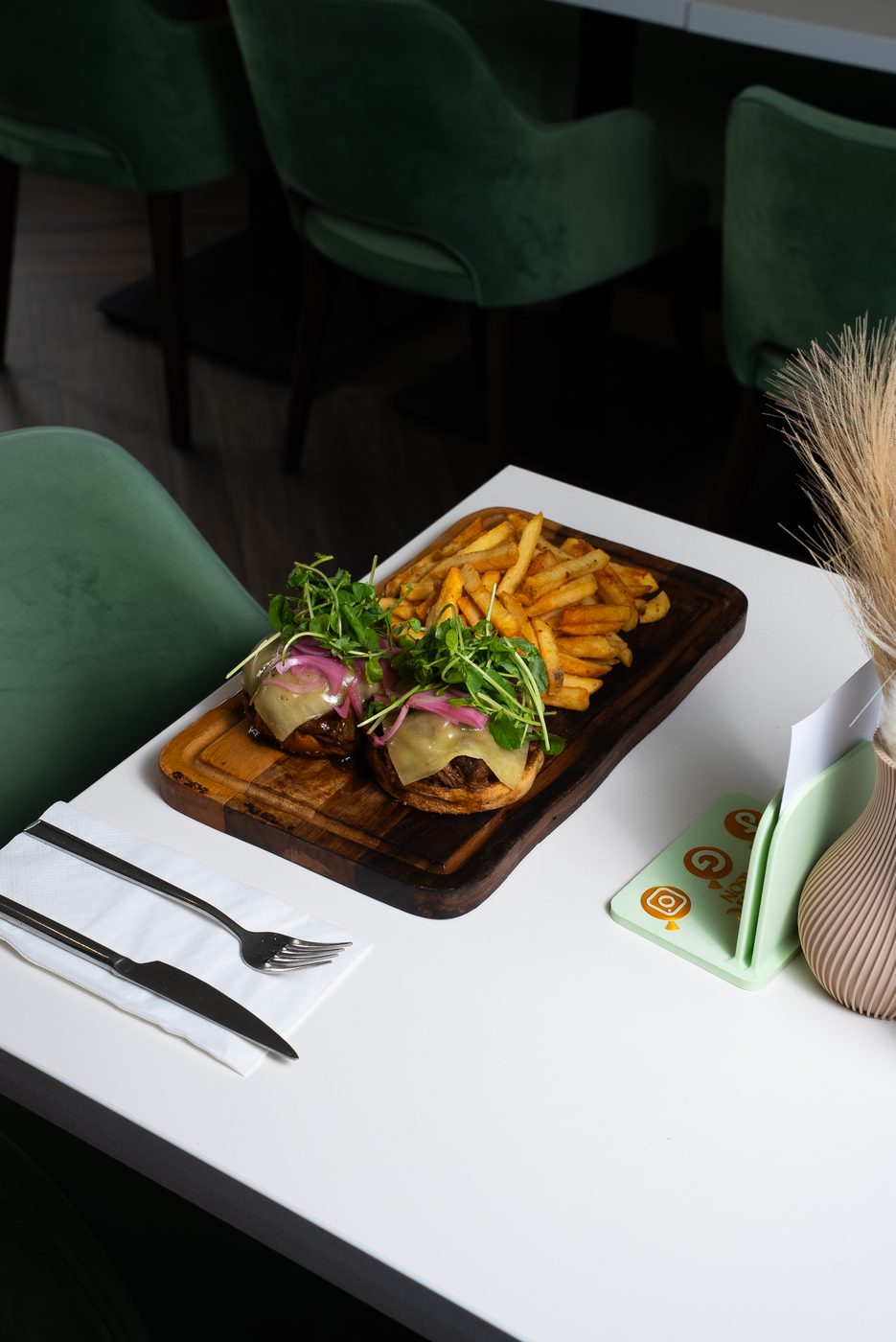 Steak sliders with fries served on a wooden board